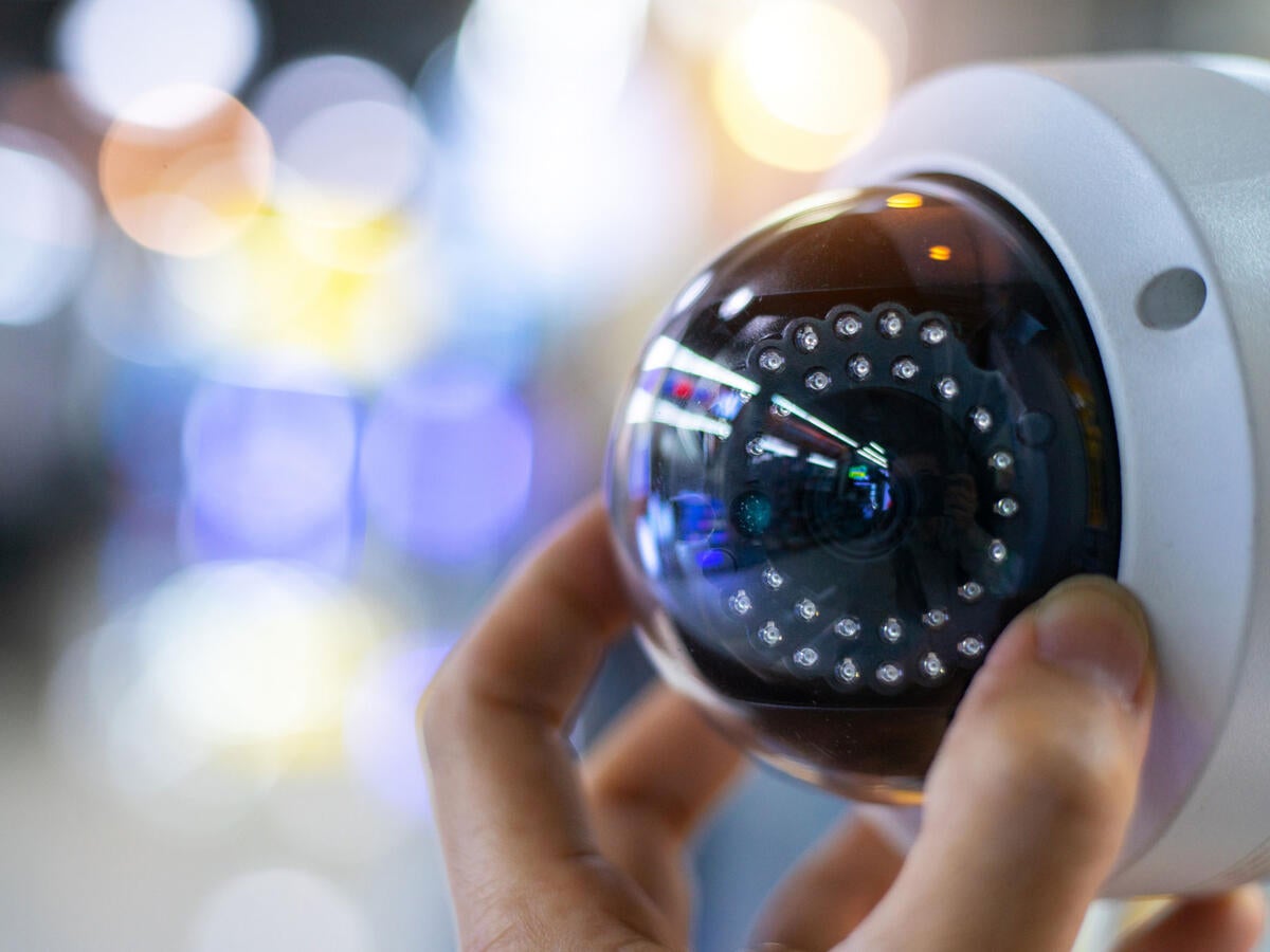 A person adjusting a security camera