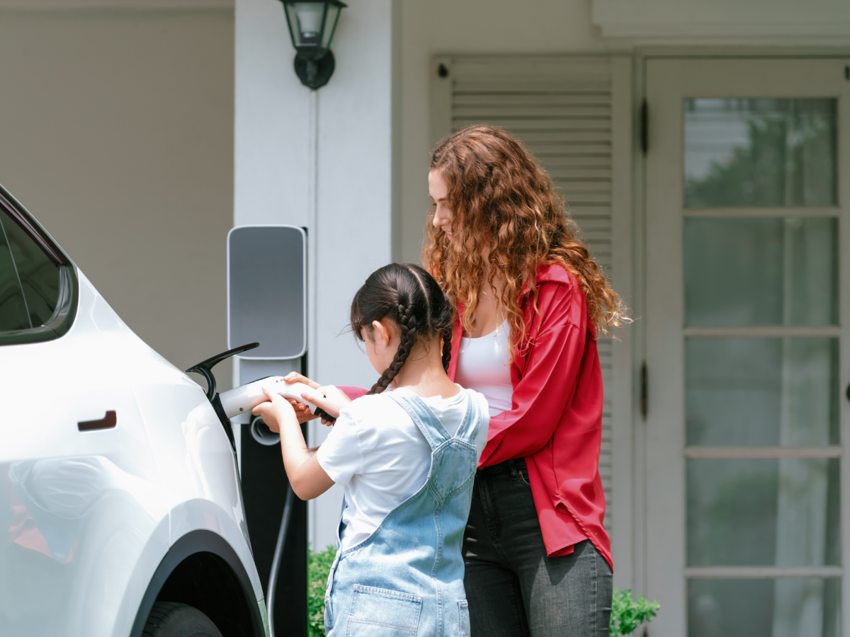mother and daughter recharging EV at home