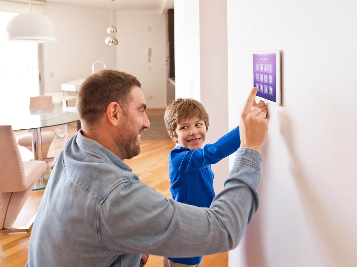Father with son controlling smart devices with a digital tablet at home