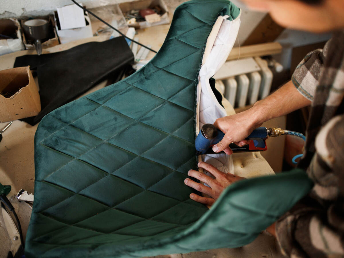 a person fixing the upholstery on a chair