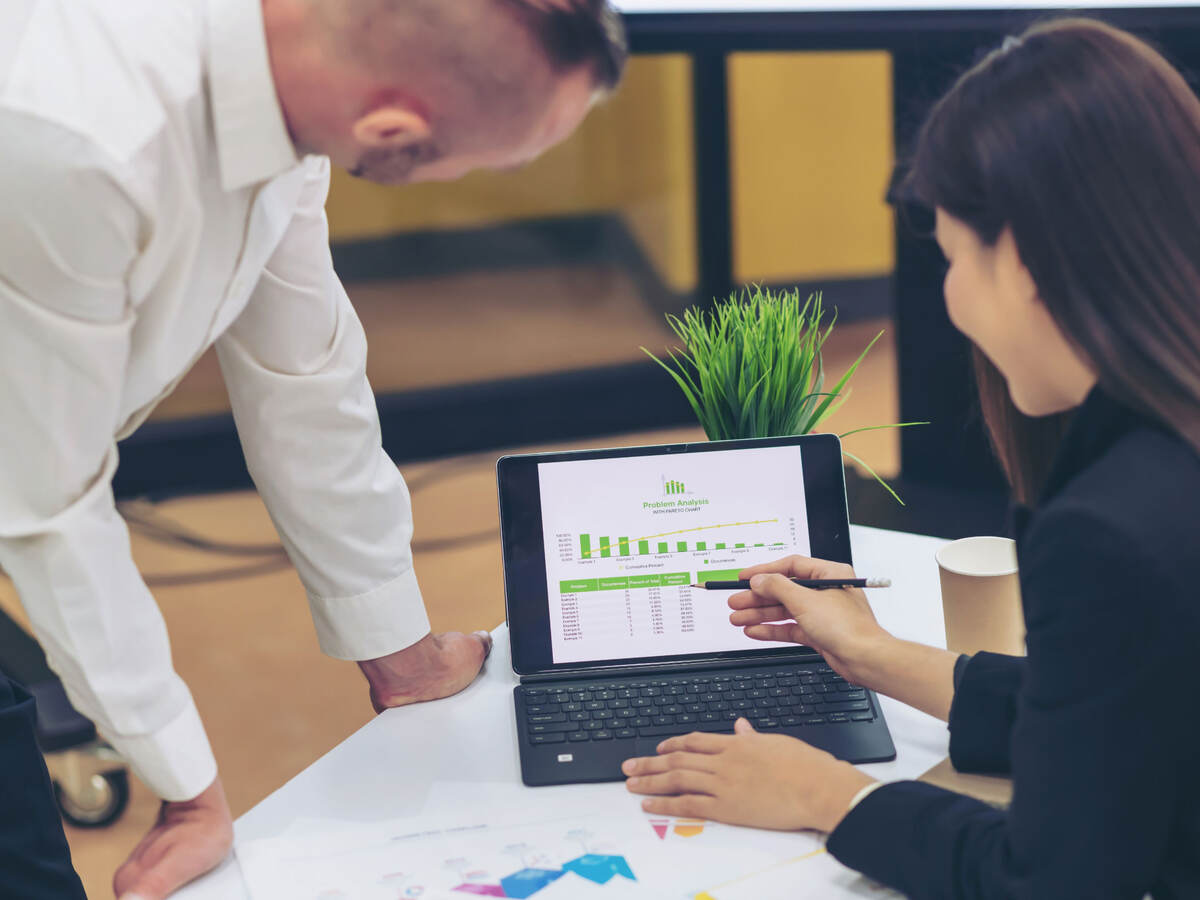 Two people looking at data on a monitor