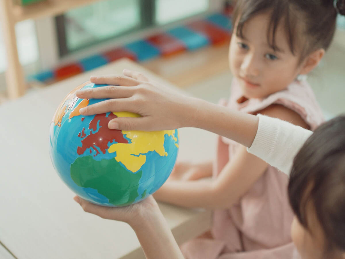 Kids playing with a toy earth globe