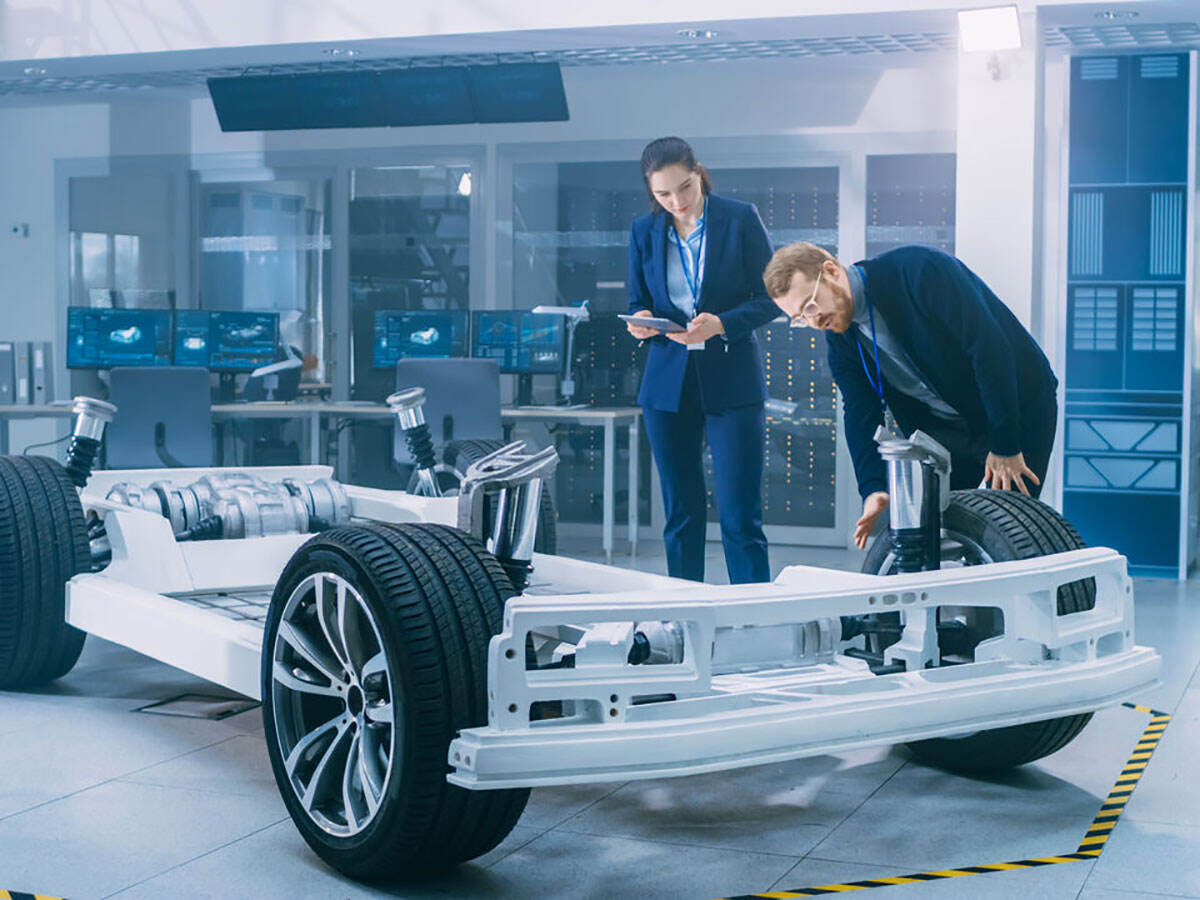 Two engineers working on an electric vehicle frame