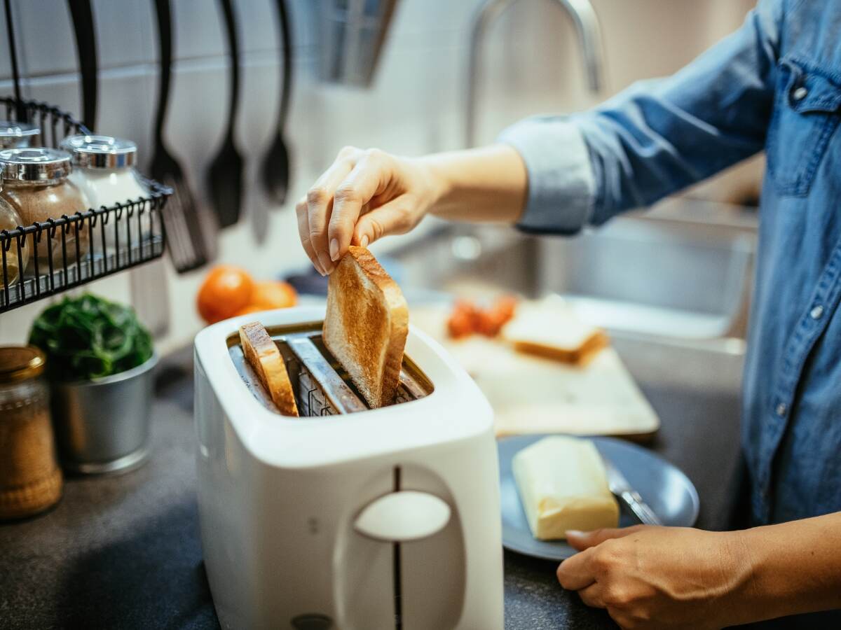 Person making toast in their kitchen