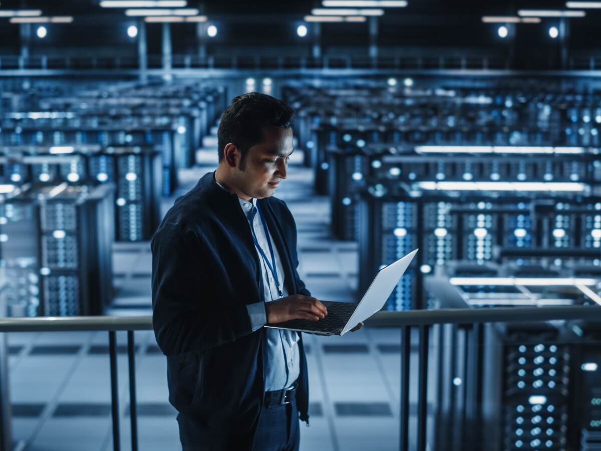 person on laptop in server room
