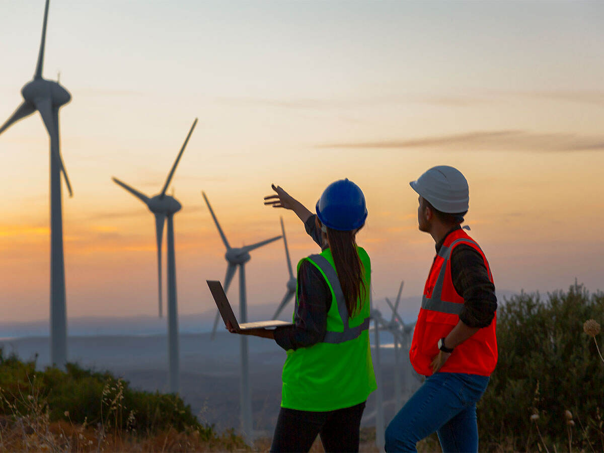people working on wind farm at sunset