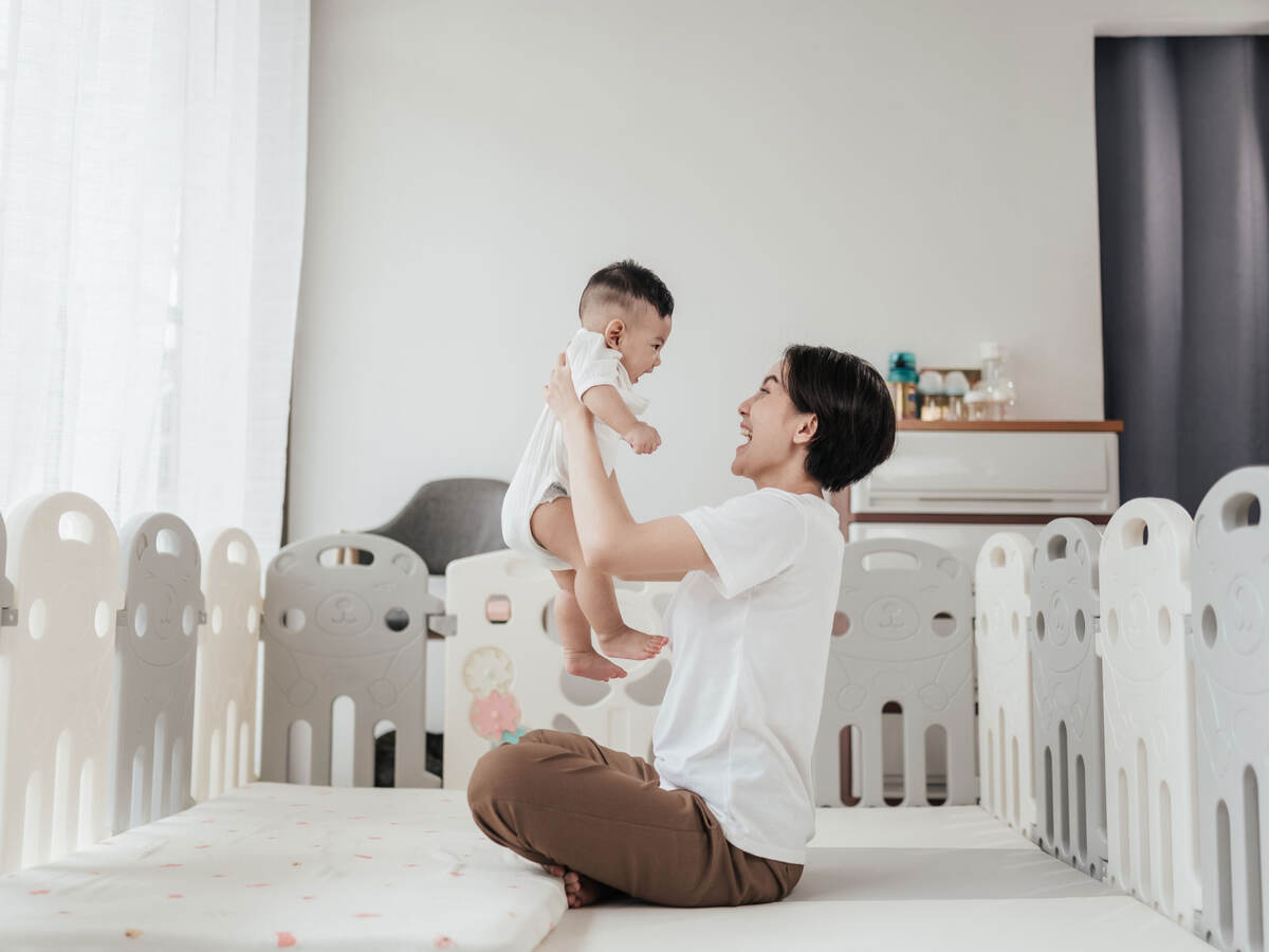A parent and child playing in a bright nursery