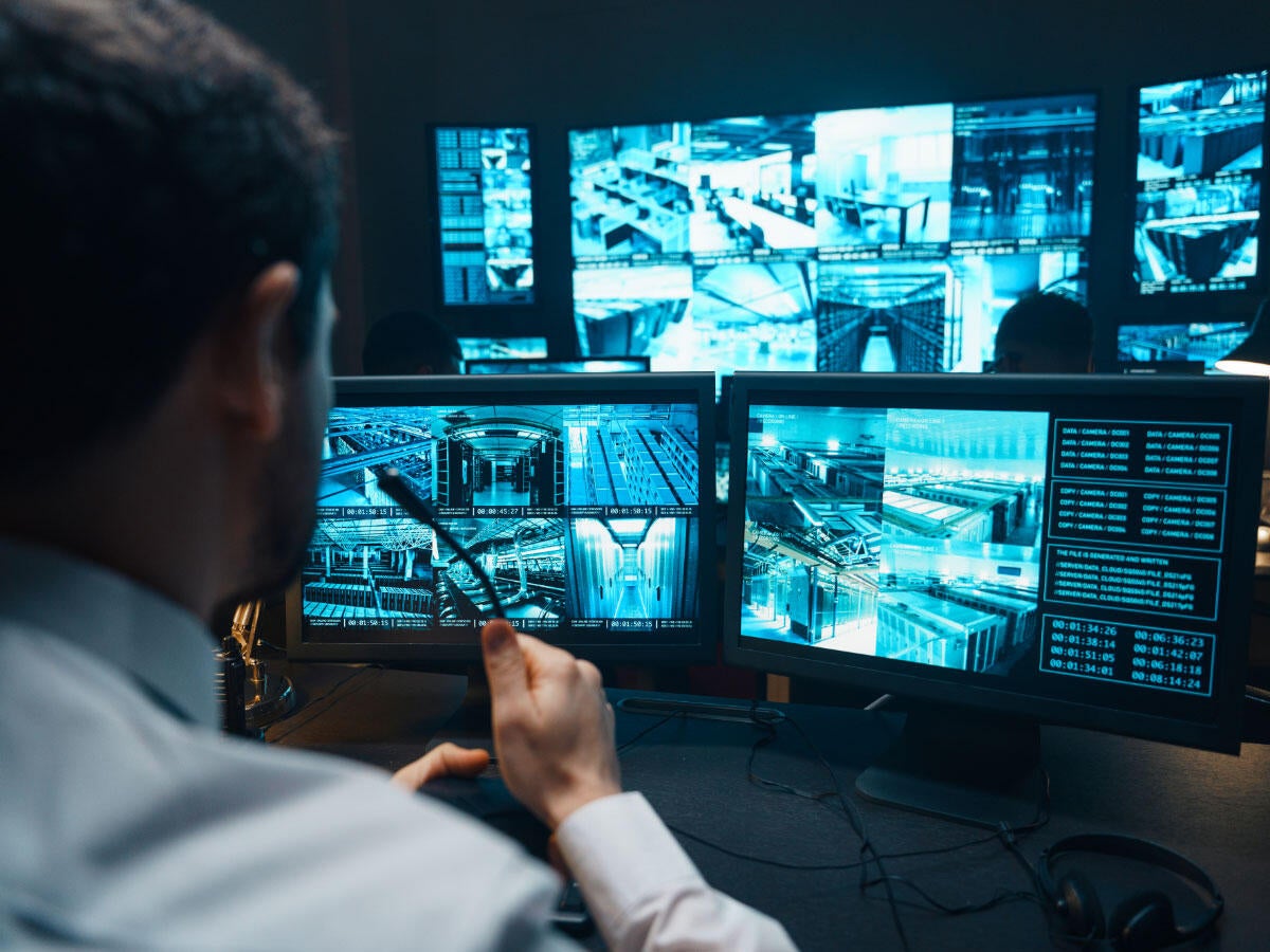 A person reviewing several security monitors