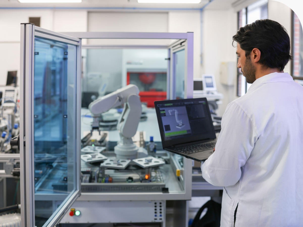 Engineer working on programming a robotic arm on a lab