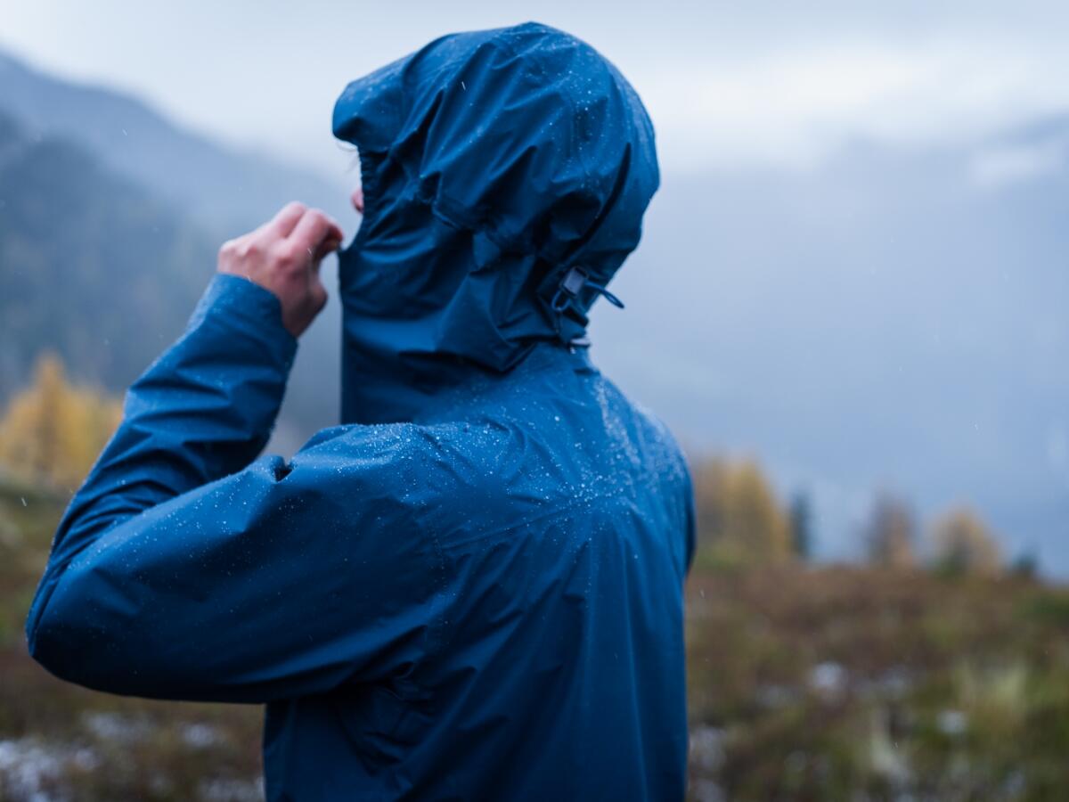 Runner adjusting weather proof clothing and rain jacket 
