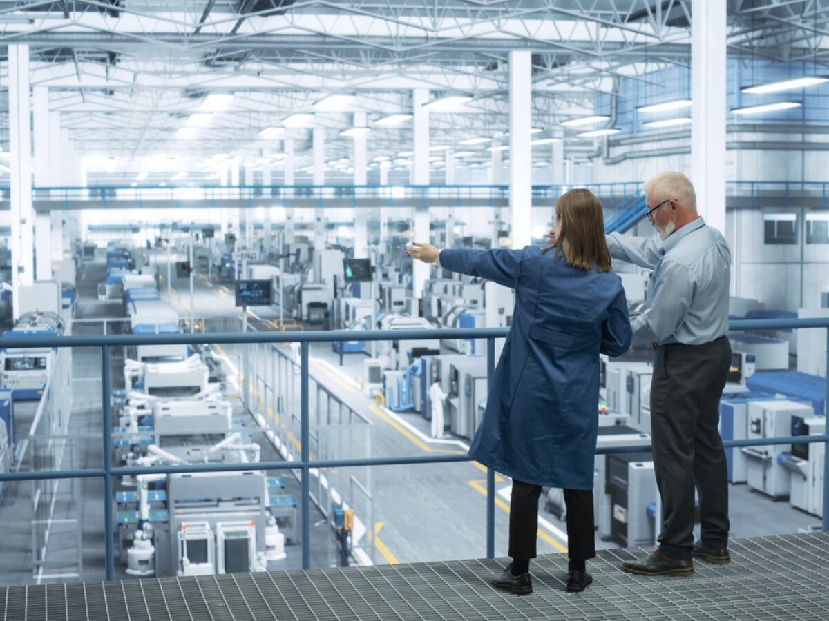Two people overlooking a factory floor