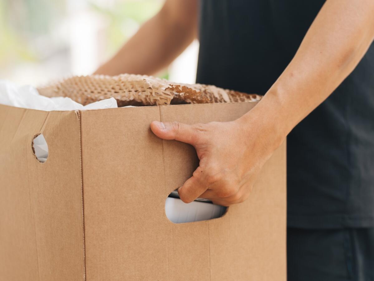 A person holding a box of recycling