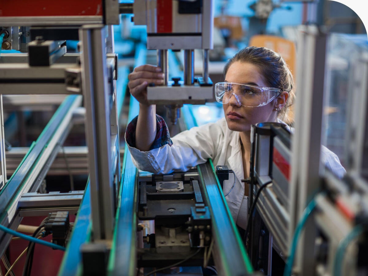 Engineer examining machine part on a production line.