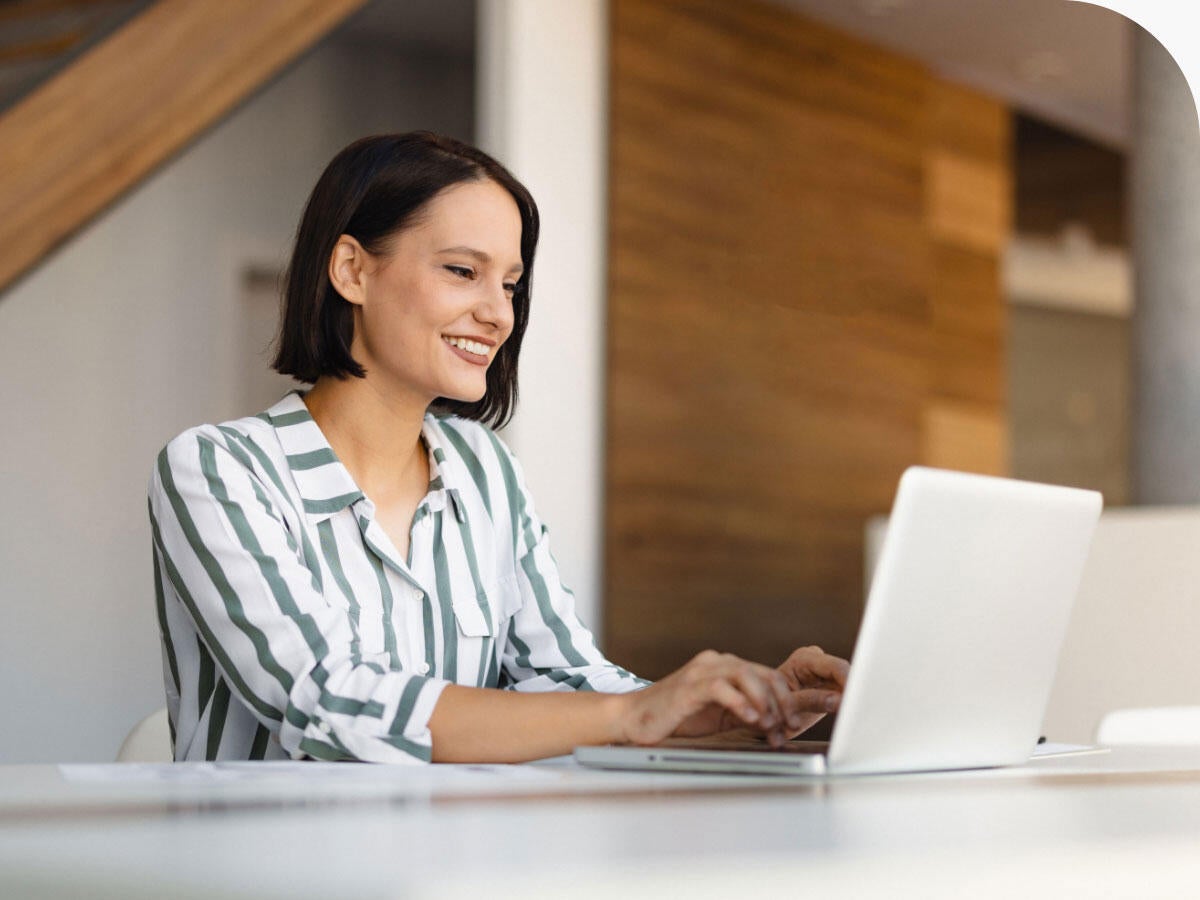 Person using a laptop while sitting at a desk