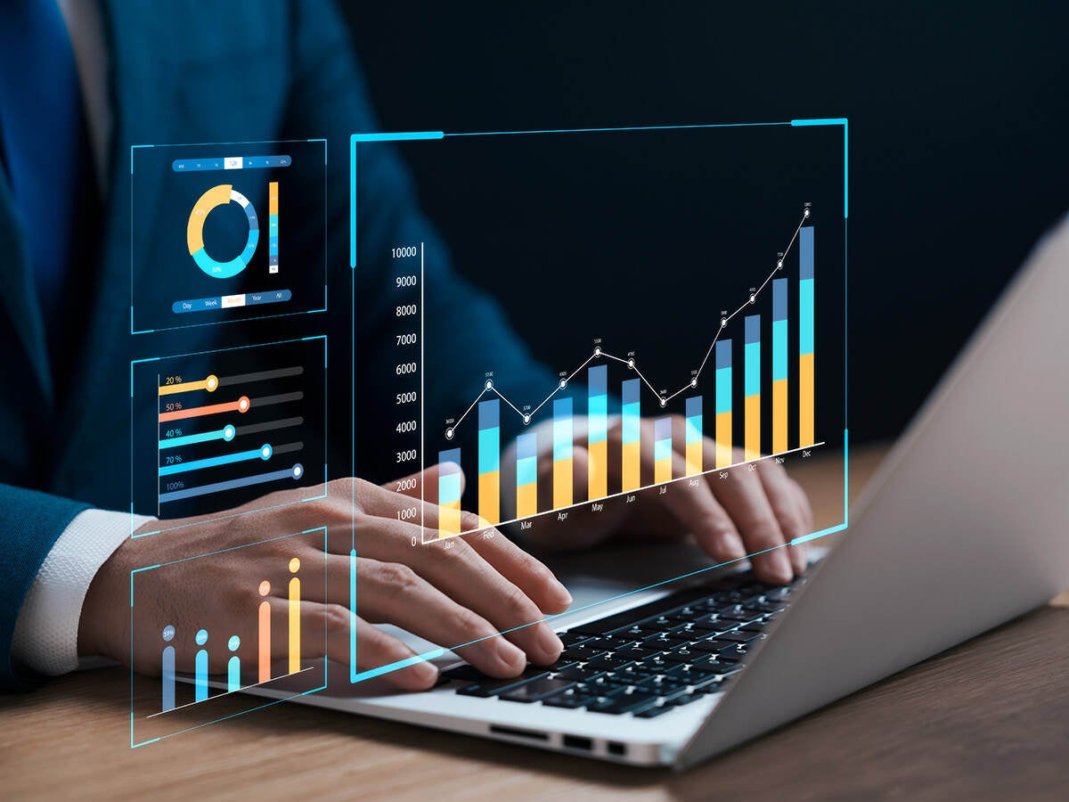 photo of hands typing on laptop with futuristic virtual graph ui on top