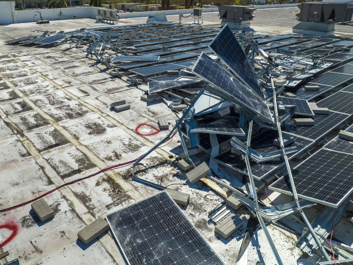 Destroyed solar panels on a roof after a storm