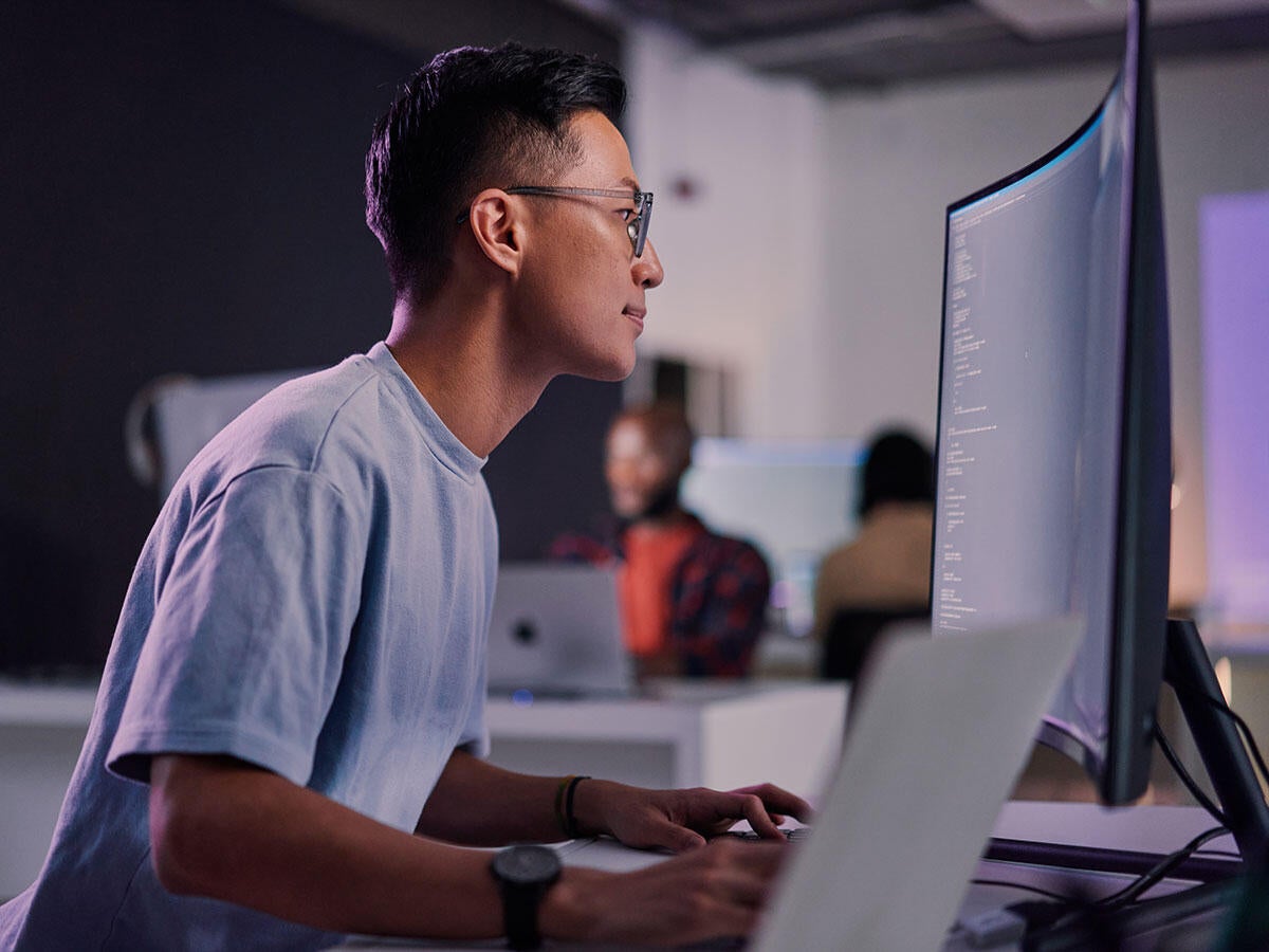 Programmer reviewing code on a large monitor