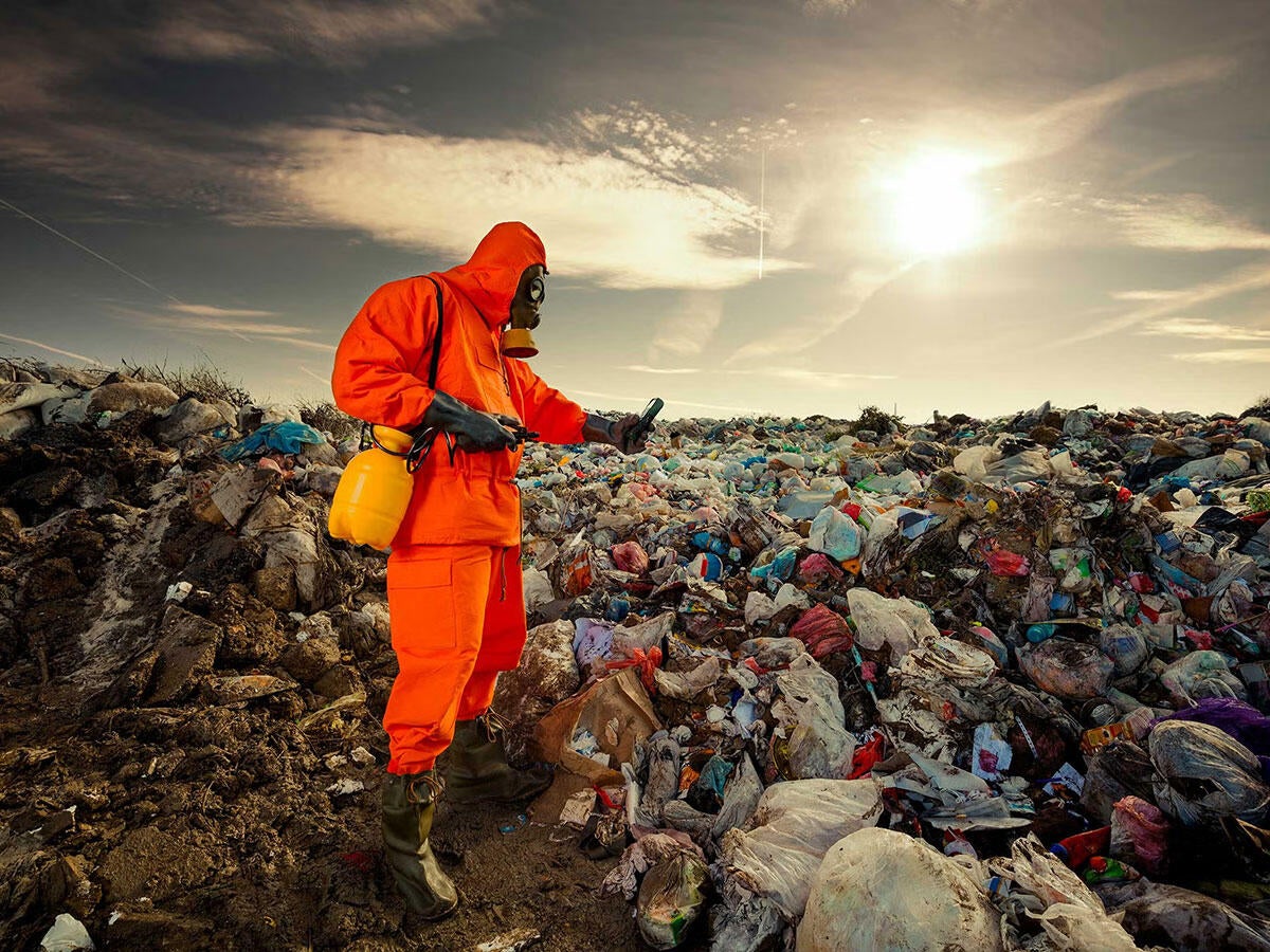 hazmat suited person working in a landfill