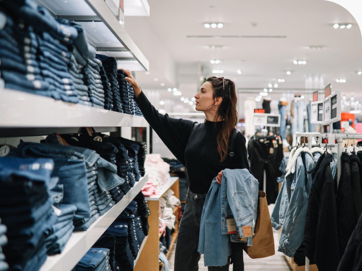 Person shopping for denim jeans in a clothing store