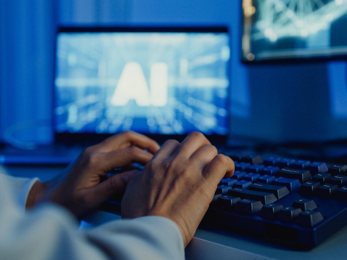 A person typing on a keyboard and using AI