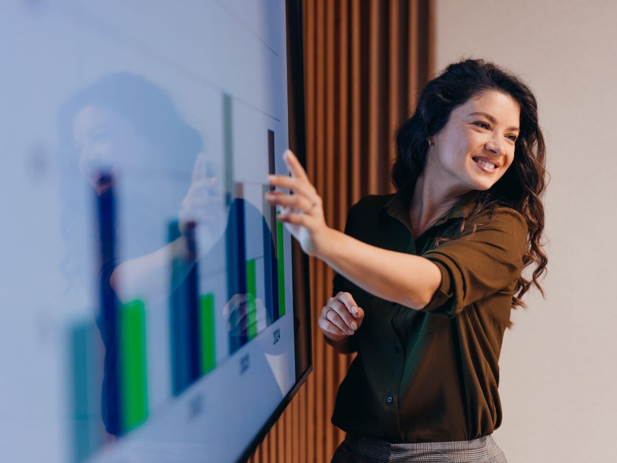 A business person presenting charts on a whiteboard