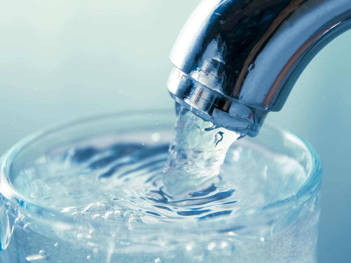 A glass being filled with water at a sink