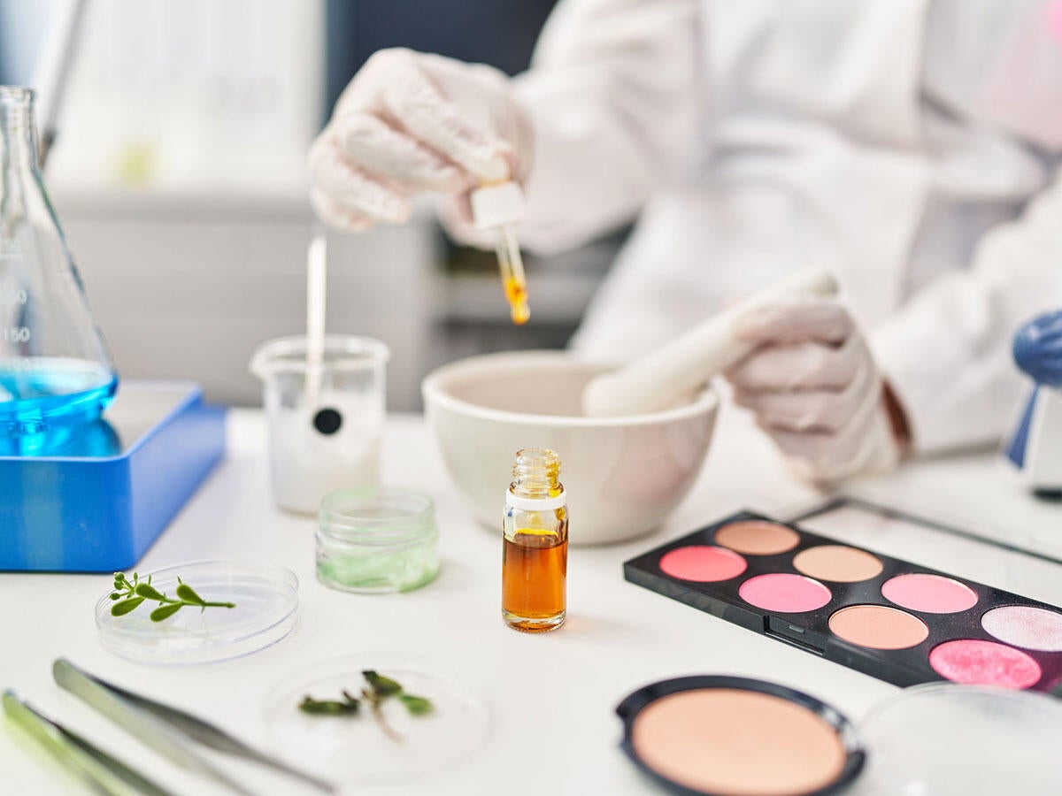 A lab technician using a dropper in a cosmetics laboratory