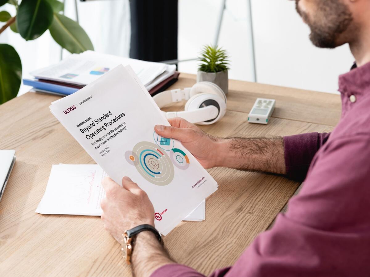 man reading the ComplianceWire training guide