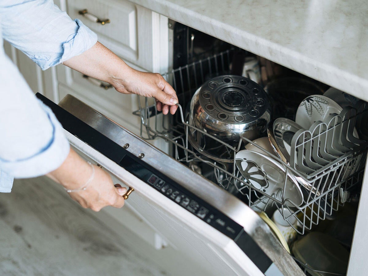 A person loading a dishwasher