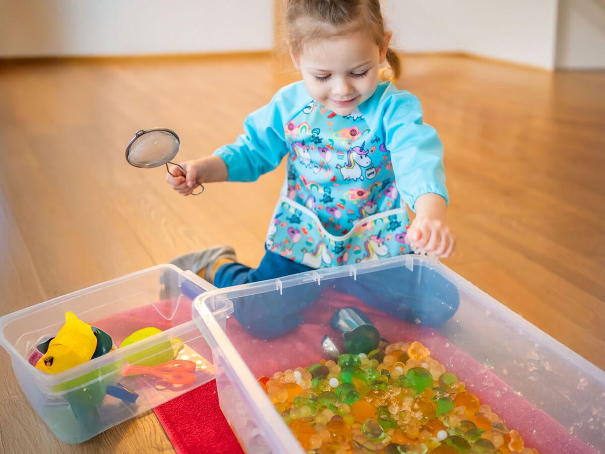 A child playing with water beads