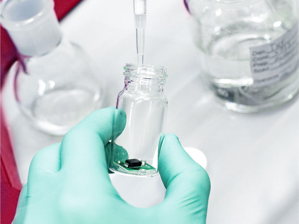 A laboratory technician using a pipette to drop liquid