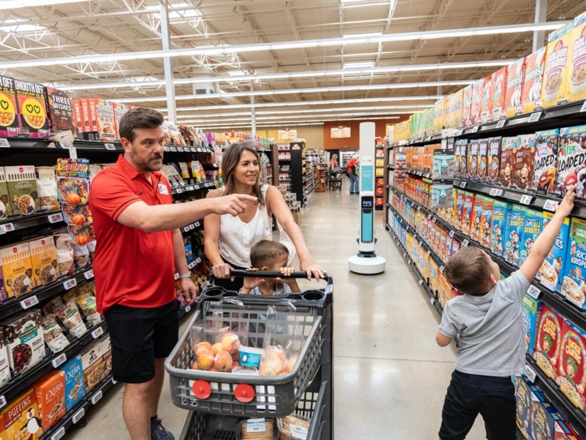 Family in grocery store with Tally shelf-scanning autonomous robot