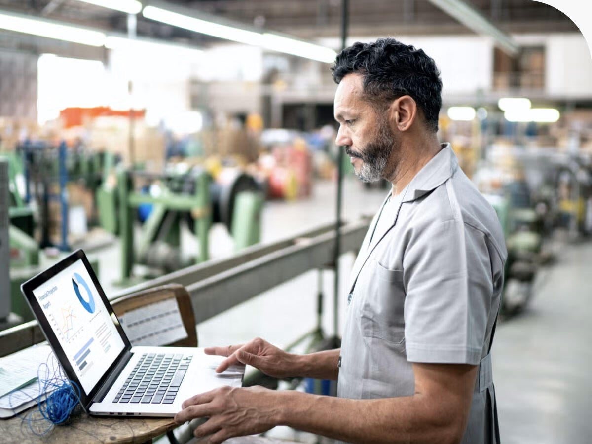 Technician using laptop while working in a factory