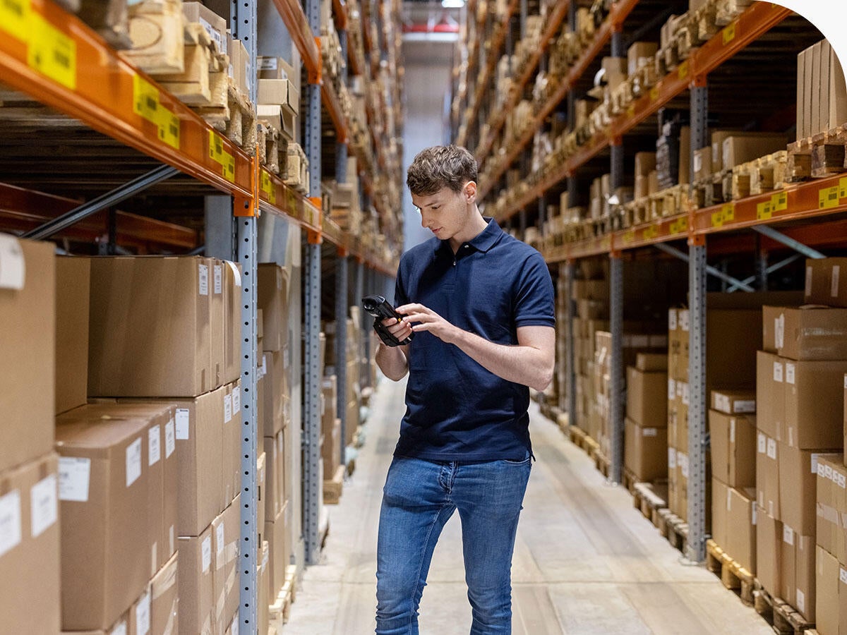 Person in a warehouse checking inventory with a scanner