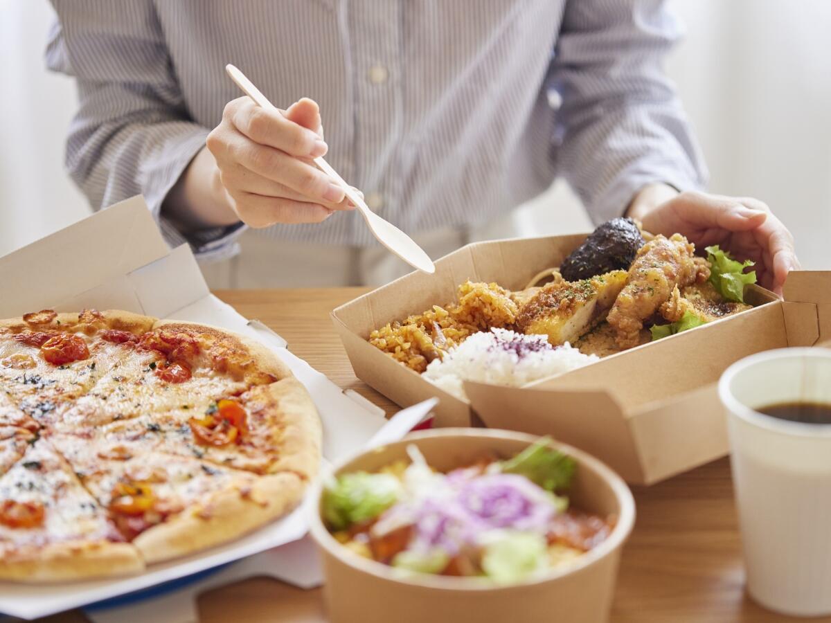 A person placing food into cardboard containers