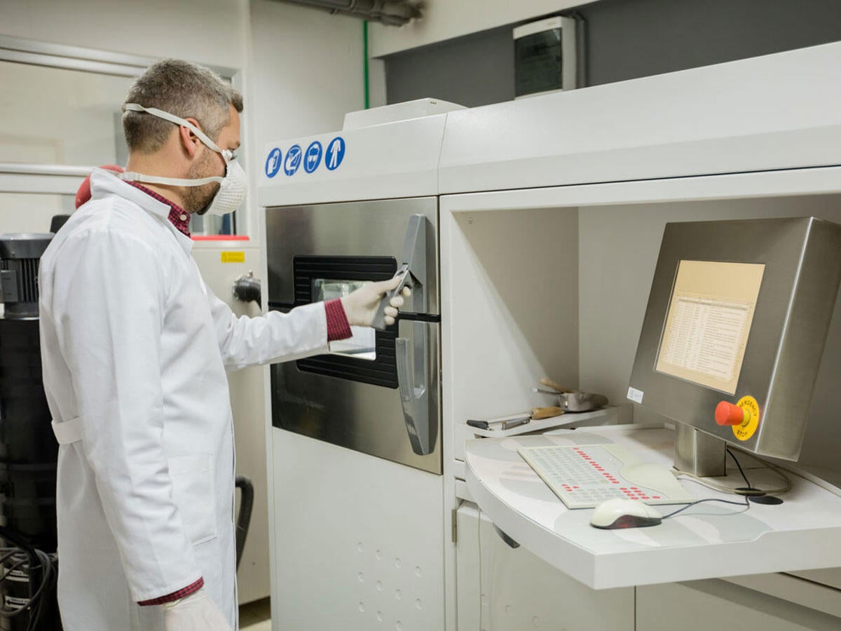 A person opening a 3D printer