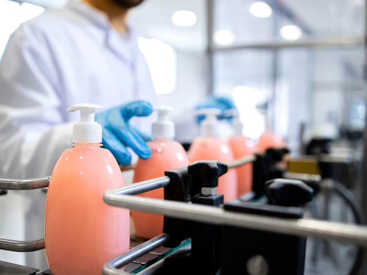A person handling detergent bottles in a laboratory