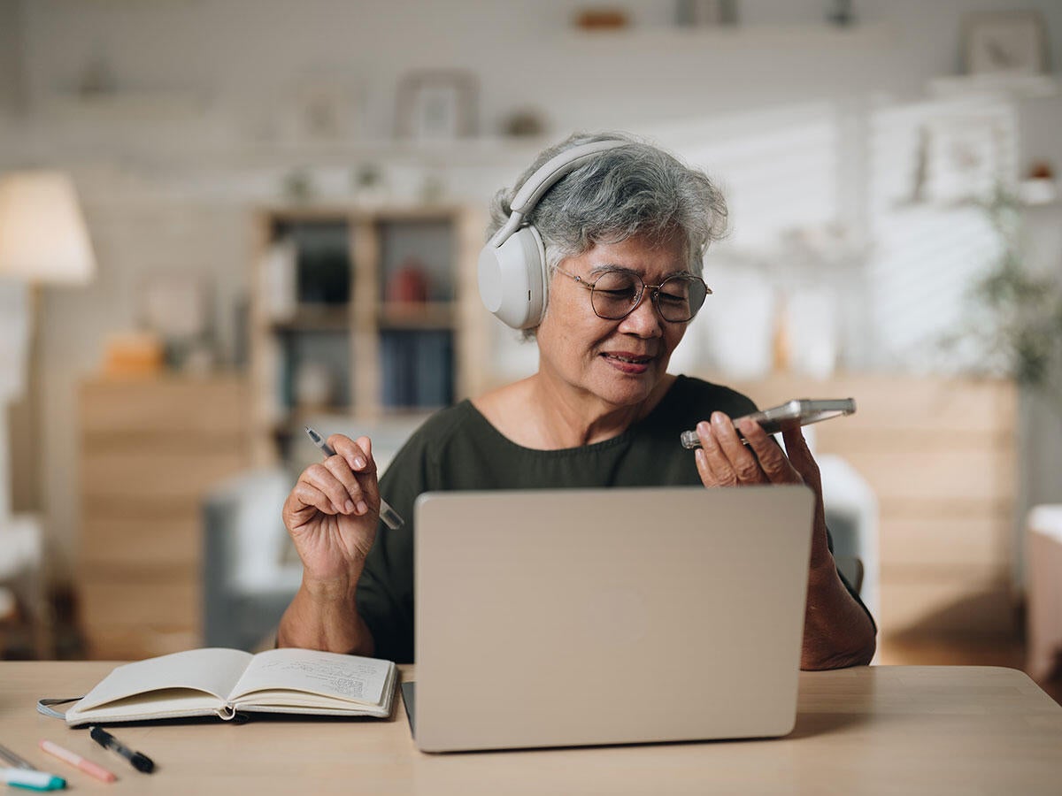 A person using a laptop and a mobile device