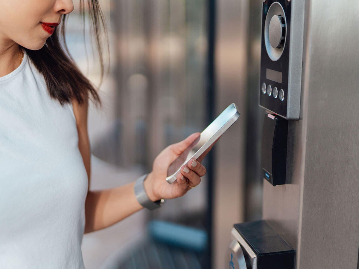 A person using a smart phone to scan a security device