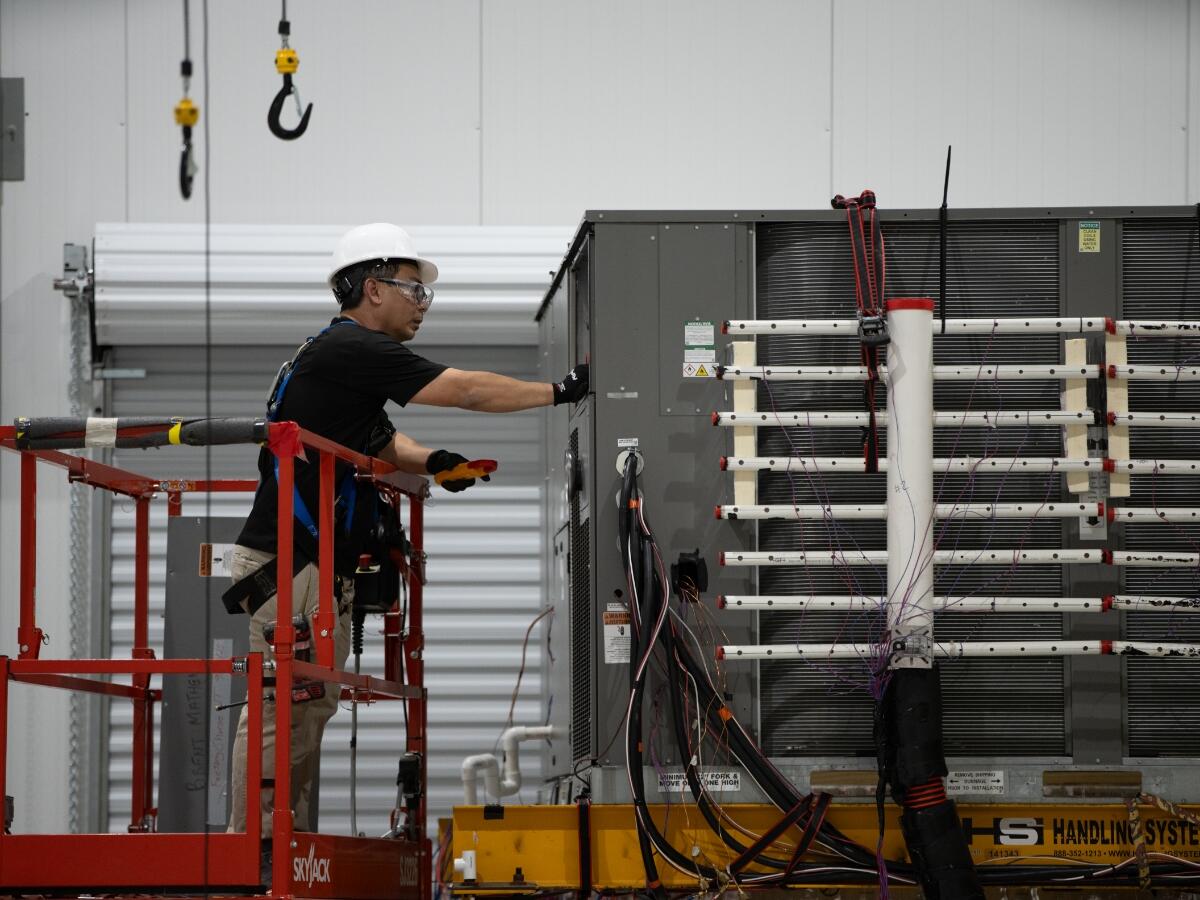 A person inspecting equipment at the Plano HVAC laboratory