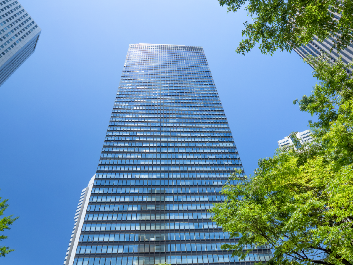 sunlit skyscraper surrounded by trees