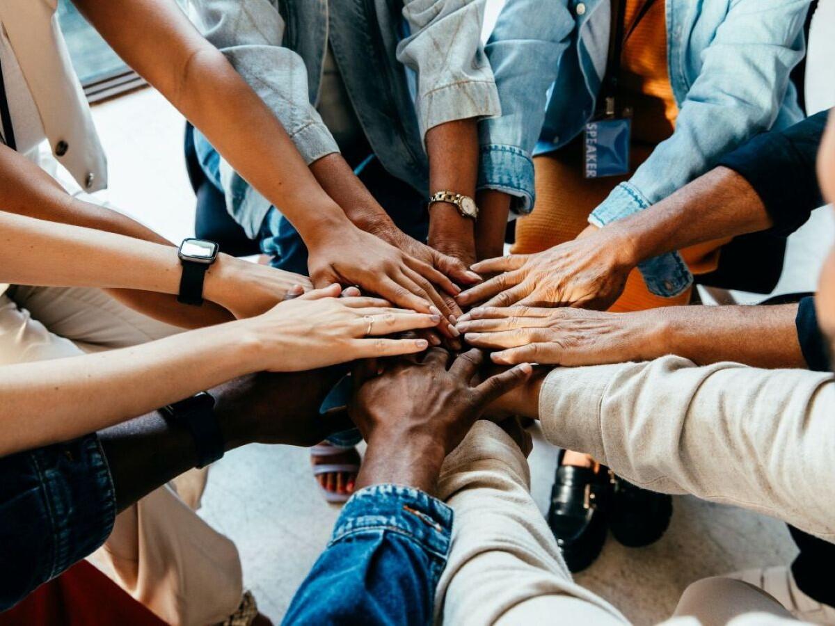 A group of people with their hands in the middle
