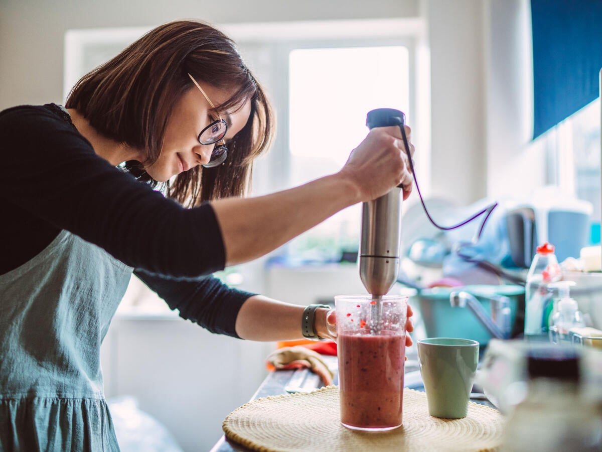 A person using a hand mixer