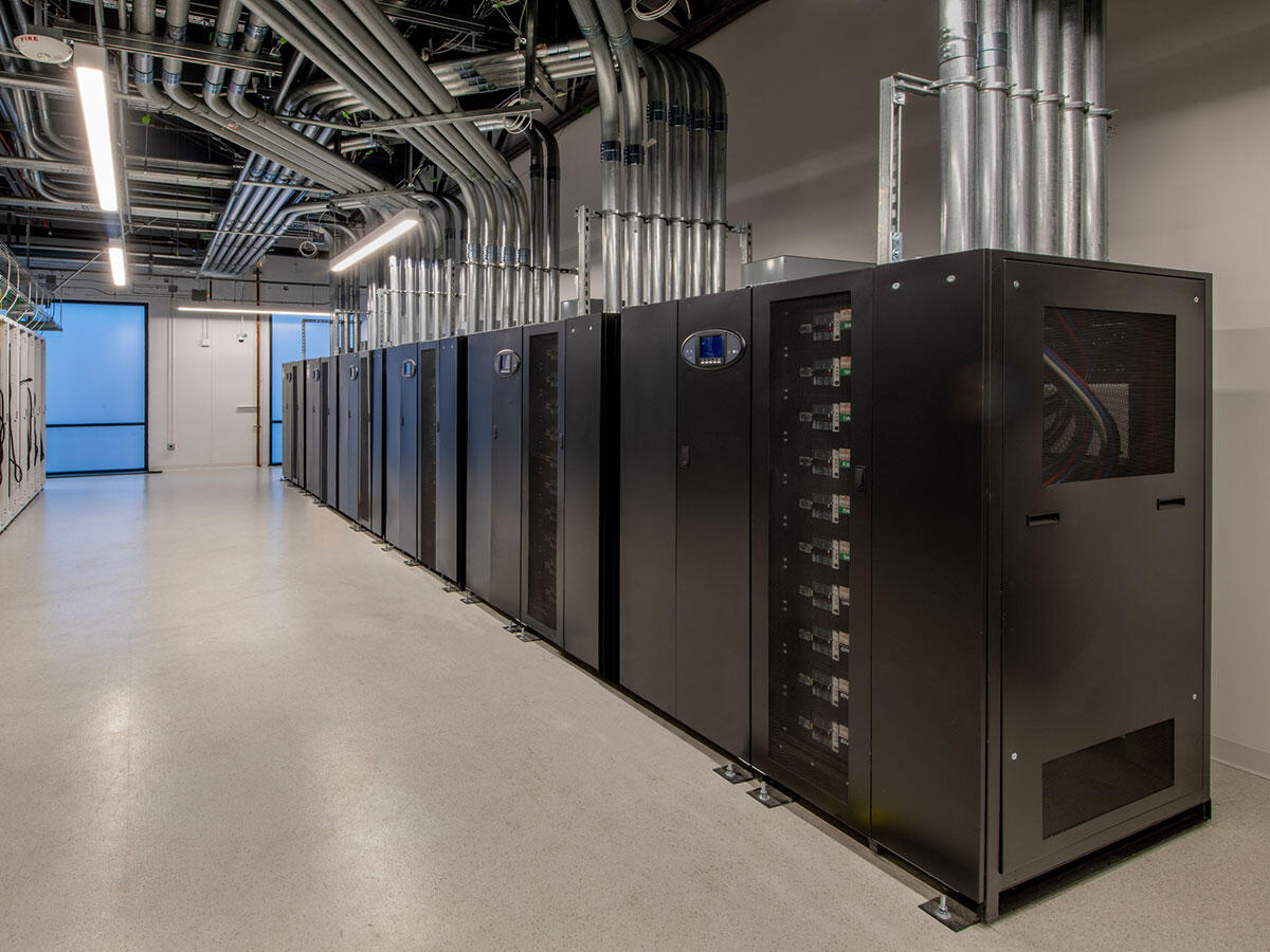 Row of server cabinets and power distribution infrastructure within a data center