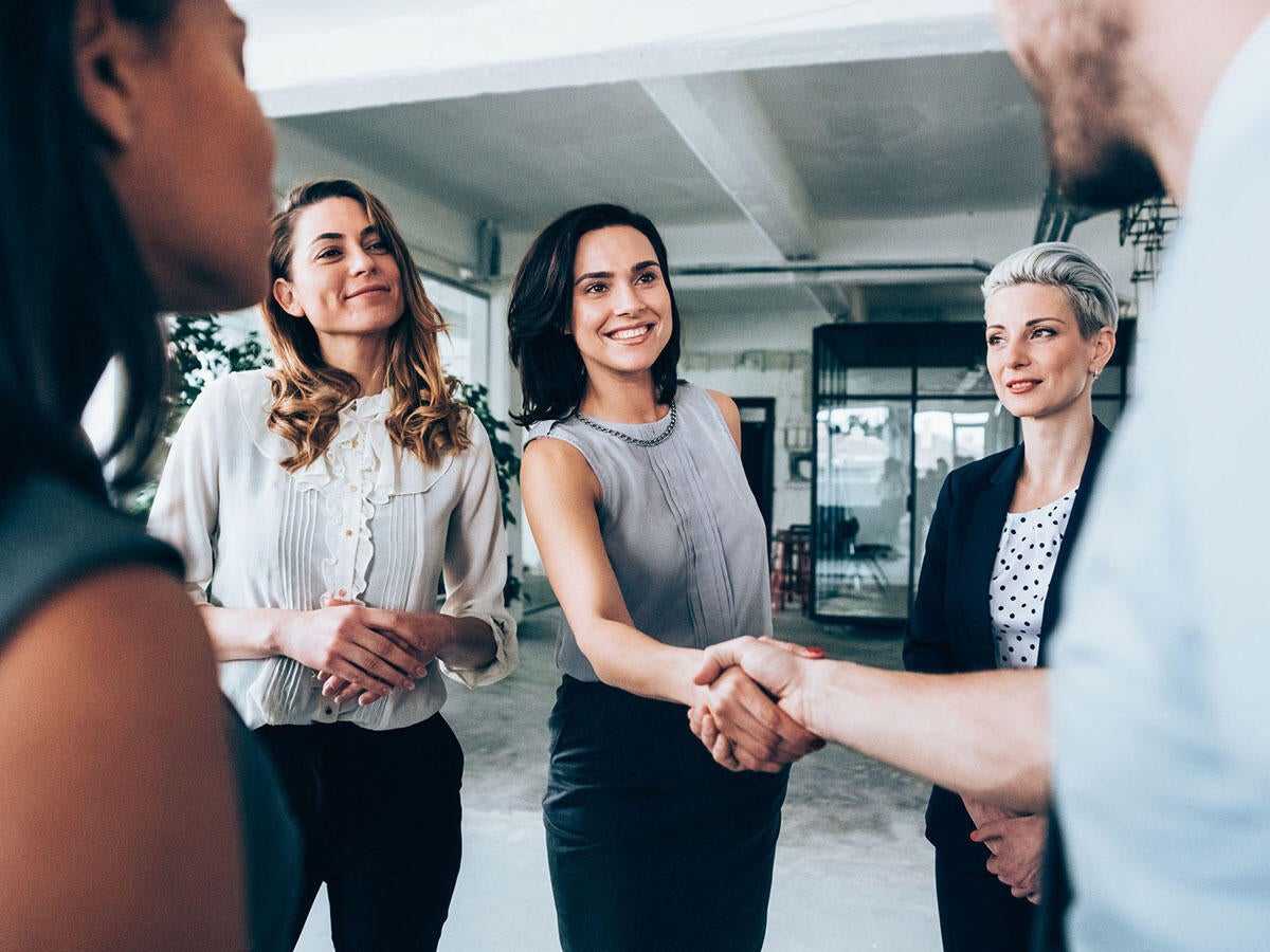 A group of people, two are shaking hands
