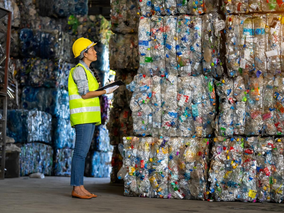Worker looking at stacks of recycled materials.
