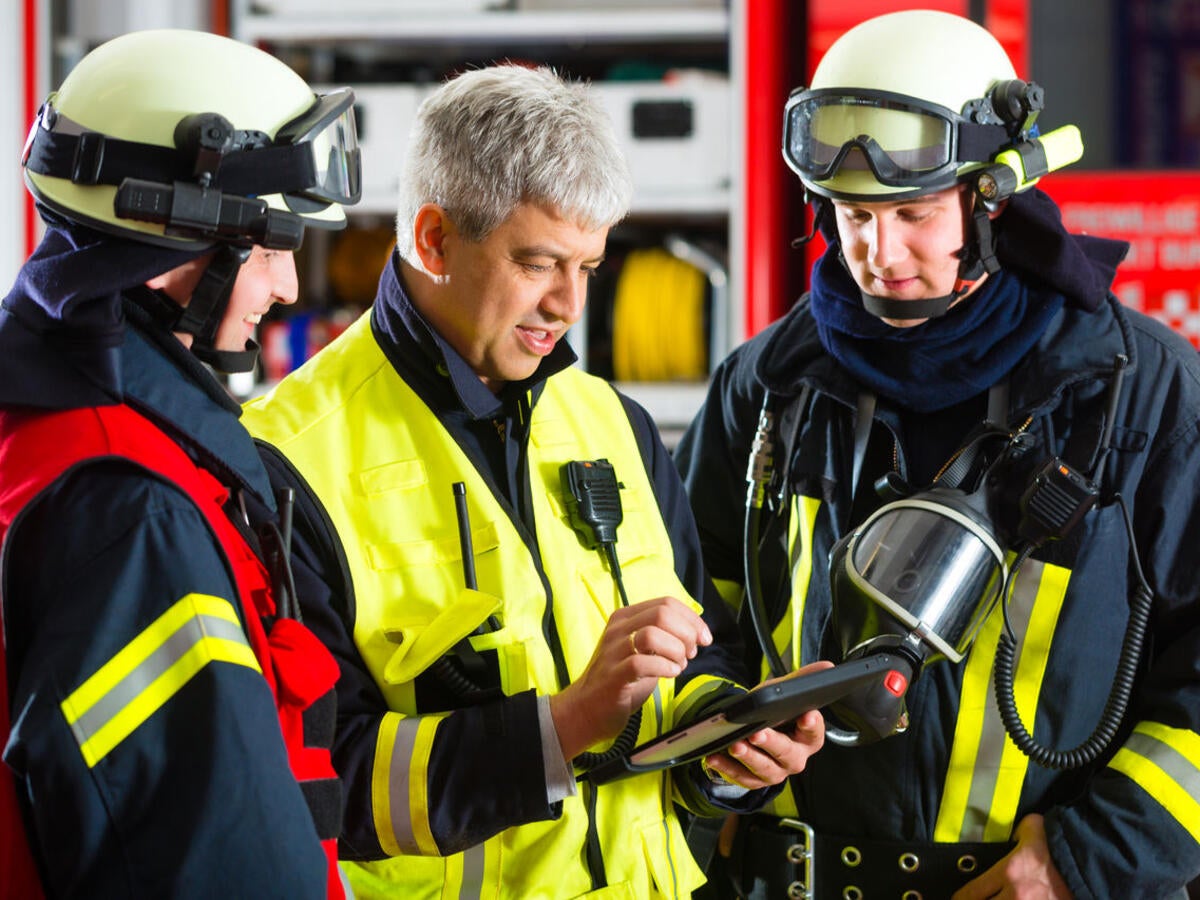 Firefighters looking at tablet.