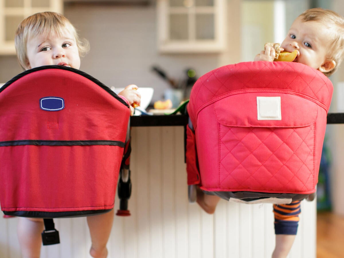 Rear view portrait of toddlers looking back from kitchen counter