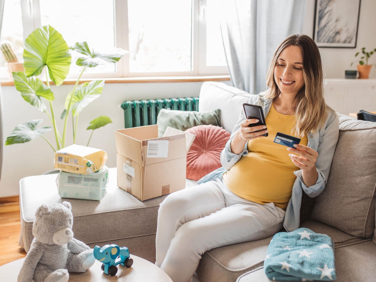 A pregnant person using a mobile device