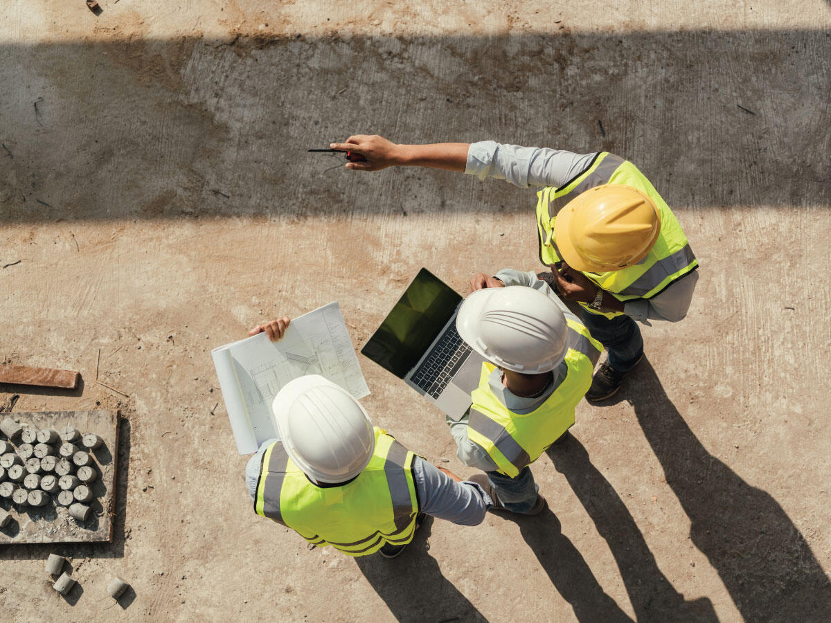 Three engineers working on schematics